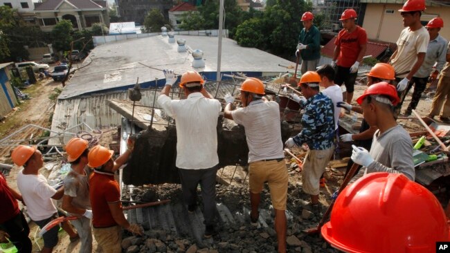 Socorristas intentan retirar escombros el domingo 23 de junio de 2019 en busca de vÃ­ctimas tras el derrumbe el dÃ­a anterior de un edificio en construcciÃ³n en Sihanoukville, Camboya. (AP Foto/Heng Sinith)