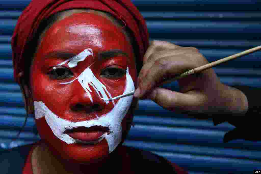 A supporter of a faction of the ruling Nepal Communist Party (NCP) gets her face painted before taking part in a &quot;victory&quot; rally after a ruling by the Supreme Court to overturn the prime minister&#39;s decision to dissolve parliament, in Kathmandu.