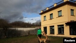 FILE - Atila and Argi, trained therapeutic greyhounds used to treat patients with mental health issues and learning difficulties, try to get the attention of Ion Albiz, 38, at Benito Menni health facility in Elizondo, northern Spain, Feb. 13, 2017. 