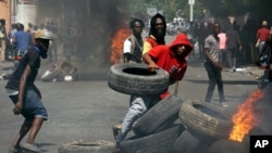 Anti-government protesters set up a barricade of burning tires as they demand the resignation of President Jovenel Moise in Port-au-Prince, Haiti, Thursday, June 13, 2019. Thousands of protesters demanding the resignation of President Jovenel Moïse.