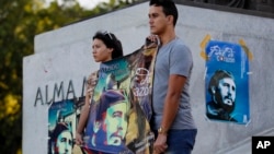 Students stand at attention holding images of Fidel Castro at the university where Castro studied law as a young man, during a vigil in Havana, Cuba, Nov. 27, 2016.