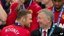 Manajer MU, Alex Ferguson (kanan) berbicara dengan penyerang MU Wayne Rooney dalam sebuah pertandingan di Stadiun Old Trafford, Manchester, England (12/5).