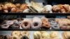 FILE - A selection of pastries, including doughnuts, bagels, rolls, croissants, turnovers and sticky buns are displayed in a New York coffee cart. In studies of mice fed fatty, Western-style diets putting them at risk for heart disease, researchers showed that AT04A reduced the total amount of cholesterol by 53 percent.