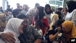 Relatives of passengers comfort each other as they wait for news on a Lion Air plane that crashed off Java Island at Depati Amir Airport in Pangkal Pinang, Indonesia Monday, Oct. 29, 2018.