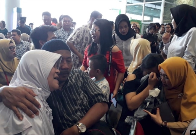 Relatives of passengers comfort each other as they wait for news on a Lion Air plane that crashed off Java Island at Depati Amir Airport in Pangkal Pinang, Indonesia Monday, Oct. 29, 2018.