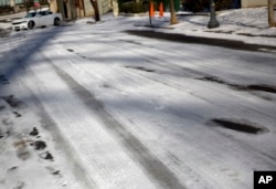 Ice covers a street as a car struggles to climb a hill in Atlanta, Jan. 17, 2018.