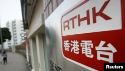 Seorang wanita berjalan melewati rumah televisi Radio Televisi Hong Kong di Hong Kong, China, 28 Januari 2007. (Foto: REUTERS/Paul Yeung)