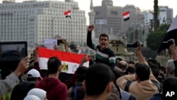 Protesters shout anti-government slogans and hold a national flag with "God is great written on it," after a judge on Saturday dismissed the case against former President Hosni Mubarak, Nov. 29, 2014.