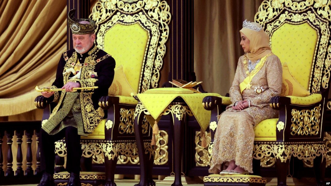 The 17th king of Malaysia, Sultan Ibrahim Iskandar, lifts a ceremonial dagger as Queen Raja Zarith Sofiah looks on during his coronation at the National Palace in Kuala Lumpur, Malaysia, on July 20, 2024. 