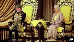 The 17th king of Malaysia, Sultan Ibrahim Iskandar, lifts a ceremonial dagger as Queen Raja Zarith Sofiah looks on during his coronation at the National Palace in Kuala Lumpur, Malaysia, on July 20, 2024. 