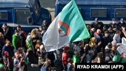 Des Algériens défilent dans une manifestation antigouvernementale dans la capitale Alger le 14 février 2020. (Photo by RYAD KRAMDI / AFP)