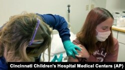 Clinical research coordinator Tammy Lewis-McCauley administers an injection as part of the hospital’s clinical trial of Pfizer's COVID-19 vaccine at Cincinnati Children’s Hospital Medical Center on Wednesday, Oct. 14, 2020. (Cincinnati Children’s Hospital Medical Center via AP)