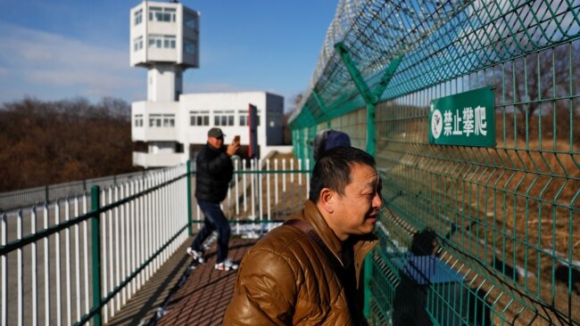 资料照：中国游客在中俄边境望向俄罗斯方向。（2017年11月24日）