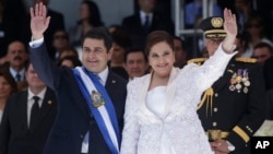 El nuevo presidente de Honduras, Juan Orlando Hernández, y la primera dama, Ana Rosalinda, saludan luego de la ceremonia de juramentación en el Estadio Nacional de Tegucigalpa.