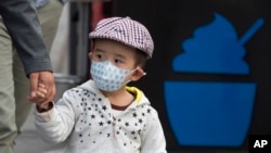 지난달 14일 중국 베이징에서 한 어린아이가 스모그 피해를 막기 위해 마스크를 쓴 채 거리에 나왔다.