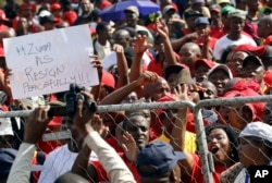 Workers hold placards during a May Day rally in Bloemfontein, South Africa, May 1, 2017.