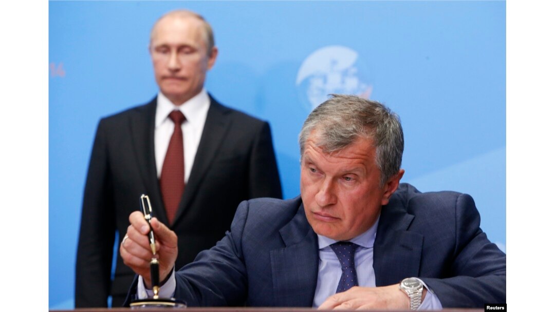 FILE - Russia's President Vladimir Putin, left, and Rosneft CEO Igor Sechin attend a signing ceremony at the St. Petersburg International Economic Forum 2014 in St. Petersburg, May 24, 2014.