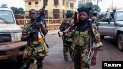 Fighters for the Seleka rebel alliance stand guard in front of the presidential palace in Bangui, Central African Republic, March 25, 2013. 