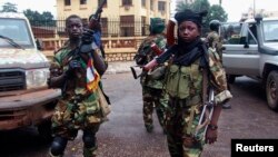 Fighters for the Seleka rebel alliance stand guard in front of the presidential palace in Bangui, Central African Republic, March 25, 2013. 