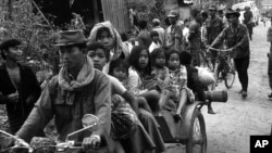 Cambodian women and children fill the back of a motorcycle taxi carrying them to safer parts of Phnom Penh as Khmer Rouge insurgents continue their artillery shelling of the capital, January, 28,1974. (AP Photo)