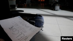A sign welcoming refugees lies on bench in the international arrivals area of Logan Airport after US President Donald Trump's executive order travel ban in Boston, Massachusetts, Jan. 30, 2017. 