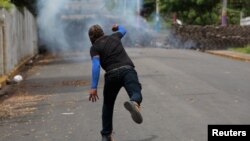 A demonstrator throws a homemade device during the funeral service of Jose Esteban Sevilla Medina, who died during clashes with pro-government supporters in Monimbo, Nicaragua, July 16, 2018.