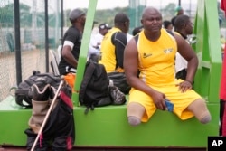 FILE— Sgt. Monday Peter whose two legs were amputated after an armored personnel carrier shattered his legs as they patroled villages in the northwestern Kaduna state in 2011, waits to take part in an exhibition sitting volleyball match in Abuja Nigeria, May 11, 2024