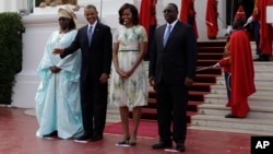 Shugaban Amurka Barack Obama yana daga hannu, a lokacin da yake jiran a dauke su a hoto, tare da mai dakin shi Michelle, da Shugaban Senegalt Macky Sall, dama, da mai dakin shi Mariame Faye Sall, a fadaar Shugaban kasa dake Dakar Senegal. Alhamis