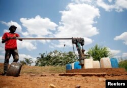 FILE - A man fetches water from a communal water point in Harare, Zimbabwe, Nov. 19, 2018. Water rationing is nothing new in Harare, but not in March. It more commonly begins months later, residents say.