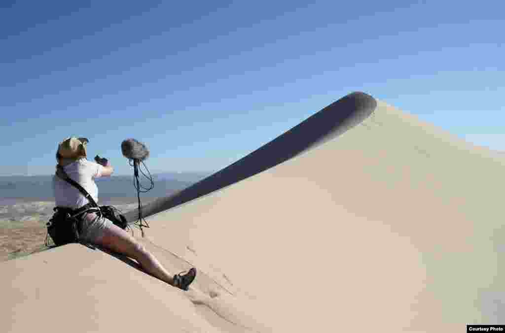 A sound engineer sets up to record the singing sand dunes in the Mohave Desert, California. (Trevor Cox)