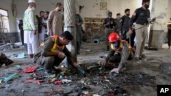 Petugas penyelamat dan polisi memeriksa lokasi ledakan bom di sebuah madrasah di Peshawar, Pakistan, Selasa, 27 Oktober 2020. (Foto: AP)