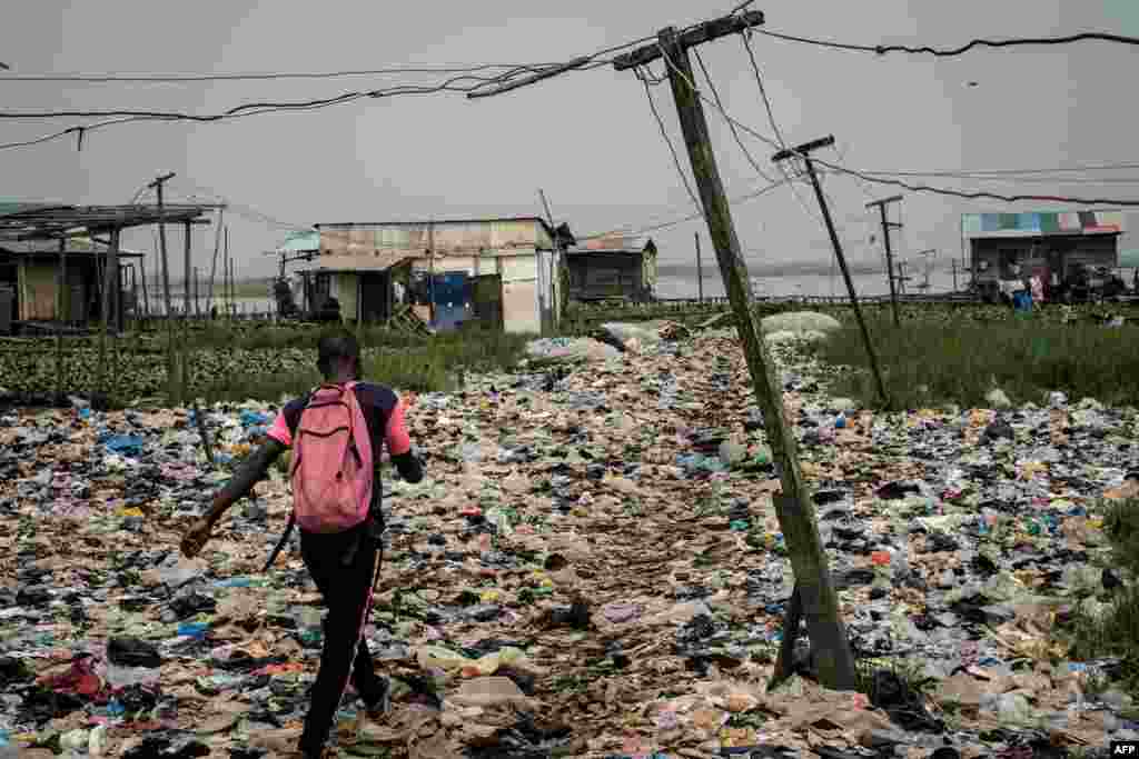 A man walks on plastic waste, used to reclaim a swamp so that the land can be developed for housing, in the Mosafejo area of Lagos, Nigeria, February 12, 2019.