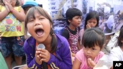 ក្រុម​អ្នកតវ៉ា​កុមារតូច​ៗ ​បាន​ស្រែកច្រៀង​បទចម្រៀង​ដើម្បី​ឲ្យ​ដោះលែង​អ្នក​ភូមិ​១៥​នាក់​នៅ​ពី​មុខ​ព្រះបរម​រាជវាំង។
