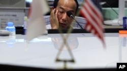 A money trader waits for calls from clients during the morning trading at a money brokerage in Tokyo Monday, Aug. 8, 2011.
