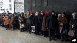 Người dân xin trợ cấp, hưu bổng xếp hàng để nhận trợ cấp tài chính tại một trong những văn phòng của chính phủ ở vùng tự xưng Cộng hòa Nhân dân Donetsk ở Donetsk, miền đông Ukraine, 12/12/2014. 