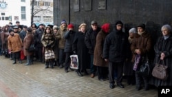 Pensioners stand in a queue to get a financial aid at one of the government offices of the self-proclaimed Donetsk People's Republic in Donetsk, eastern Ukraine, Dec. 12, 2014. 