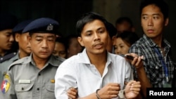 为路透社工作的缅甸记者觉梭2018年6月庭讯后被带离法庭