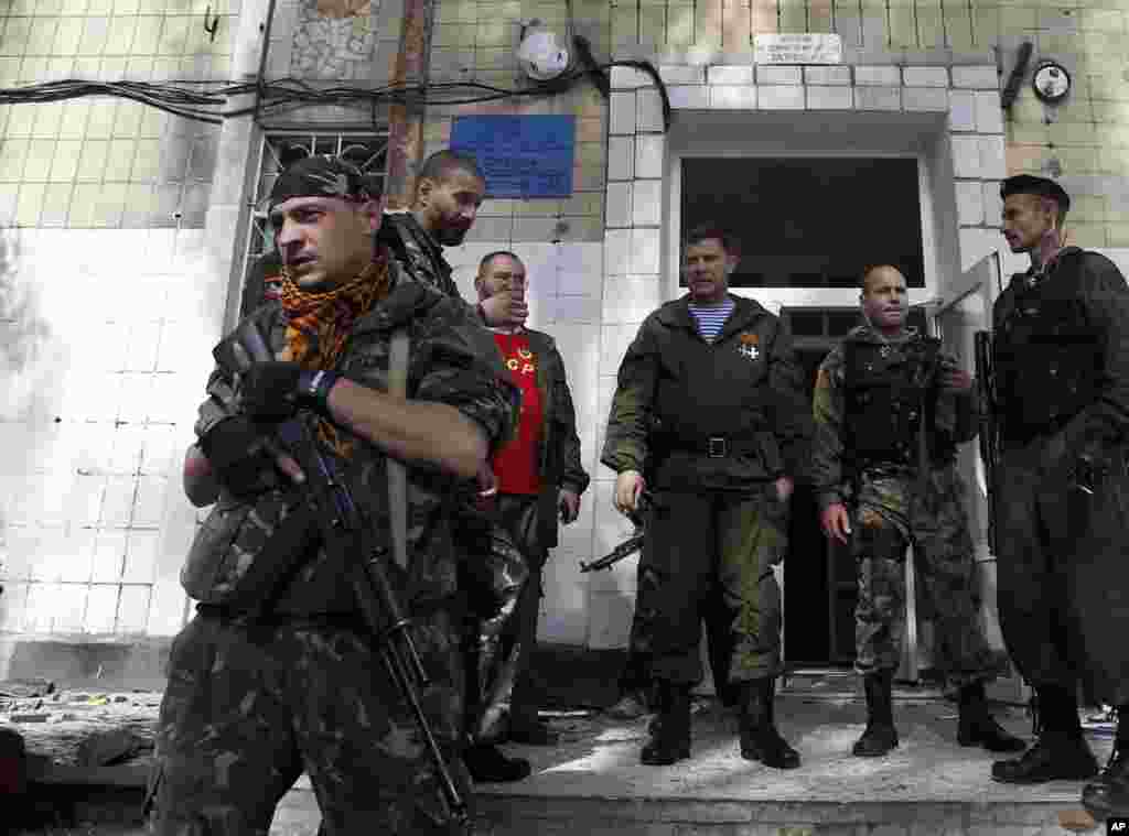 Alexander Zakharchenko, center, the leader of pro-Russian rebels in Donetsk, observes the damage at a school after shelling in Donetsk, eastern Ukraine, Oct. 1, 2014.