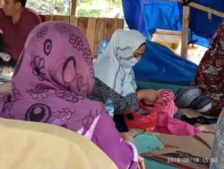 Pengungsi perempuan asal Afghanistan sedang menyulam di tenda pengungsi seberang Rudenim Jakarta hari Rabu (19/6). (Foto: VOA/Sasmito)