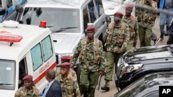 Kenyan security forces walk away from the hotel complex at the scene of the attack in Nairobi, Kenya, Jan. 16, 2019.