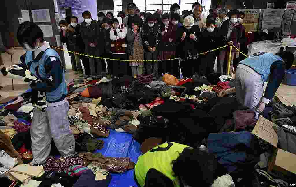 Эвакуированные жители ждут раздачи подержанных товаров и одежды 24 марта 2011 г. 
