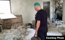 FILE: In this May 2014 photo, a Syrian doctor surveys the wreckage inside an Aleppo hospital.