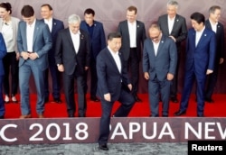 Leaders disperse after posing for a family photo ahead of the retreat session during the APEC Summit in Port Moresby, Papua New Guinea, Nov. 18, 2018.