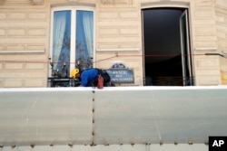 A worker sets up protections on the famed restaurant Fouquet's of the Champs-Elysees, in Paris, March 22, 2019. French President Emmanuel Macron announced that soldiers would be deployed across the country to help maintain security during "yellow vest" protests.