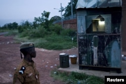 A soldier surveys damage caused by fighting after the Burkinabe army took control of the Naaba Koom military camp in Ouagadougou, Burkina Faso, Sept. 30, 2015.