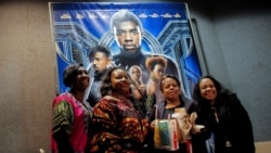 FILE PHOTO: A group of women pose for a photo in front of a poster advertising the film "Black Panther" on its opening night of screenings in Manhattan, New York, U.S., February 15, 2018. REUTERS/Andrew Kelly/File Photo