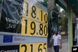 A stock monitor shows exchange rates on a storefront in Mexico City, Mexico, May 31, 2019, a day after U.S. President Donald Trump's threat to impose a 5% tariff that could rise substantially on all Mexican imports. The peso dropped more than 3% against the U.S. dollar by Friday morning.