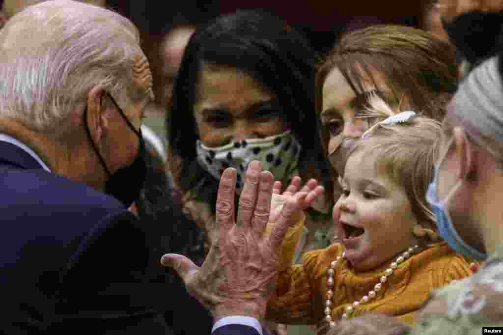 U.S. President Joe Biden high fives 16-month-old Breklyn Petroelje as he gathers with service members and military families during a Thanksgiving event at Fort Bragg, North Carolina,&nbsp; Nov. 22, 2021.