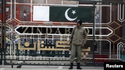 A paramilitary soldier stands guard beside a border gate at the India-Pakistan joint check-post at the Wagah border near Lahore, January 6, 2013. 
