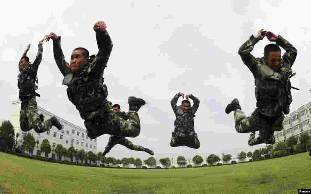 Paramilitary policemen jump as they practice during a summer drill in Bozhou, Anhui province, China. 